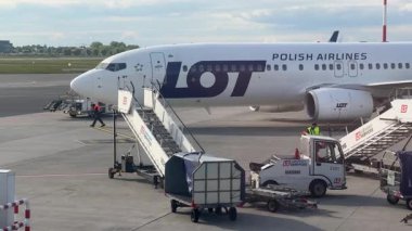 Nice, Fransa - 13 Mayıs 2025: Polonya Havayolları uçağı yer ekibi bir sonraki uçuş için bavullarını yüklerken ve havaalanı faaliyetlerini ön plana çıkarırken