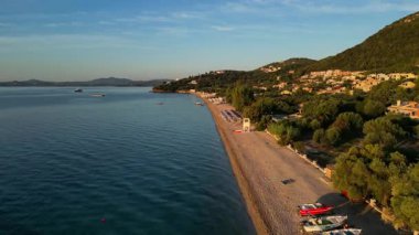 Corfu Island, Greece. Coastal scene unfolds with calm waters and sandy beach, highlighting vibrant shoreline and lush greenery, creating a peaceful atmosphere for relaxation and enjoyment