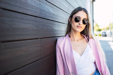 Alışveriş merkezinin dışında duran kendinden emin ve güçlü genç bir kadın. Yüksek kalite fotoğraf