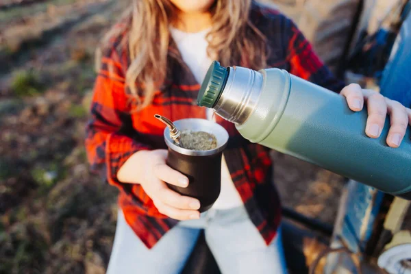 Young latin woman drinking mate in a natural space, on top of a little tractor. Latin beverage. Ethnical concept. High quality photo. Horizontal