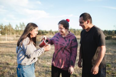 Gün batımında kırsalda sıcak su ile termo kullanan iki gülen arkadaş. Yüksek kalite fotoğraf
