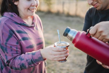 Tanımlanamayan iki arkadaş, gün batımında yerba çiftliğine termosu ile su servisi yapıyorlar. Yüksek kalite fotoğraf