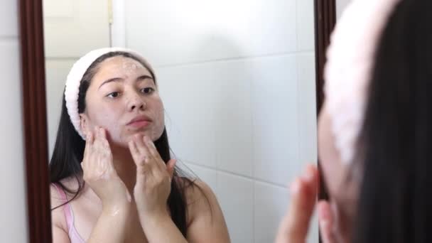 镜子里的年轻女人在她的脸颊上用玫瑰石英般的面部滚筒 美肤护理 4K视频 — 图库视频影像