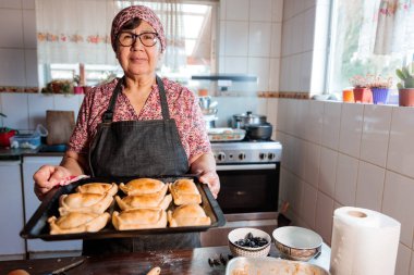 Mirasın Lezzetleri: Latin Yaşlı Kadın Şili usulü Pişirilmiş Biftek Yemeğini Ev Mutfağının Sıcaklığında Hazırlıyor. Yüksek kalite fotoğraf