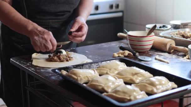 本格的な料理の伝統 ラテン高齢の女性は 彼女の田舎ホームキッチンの快適さで美味しいチリのベーキングエパンダを作りました 4Kビデオ — ストック動画