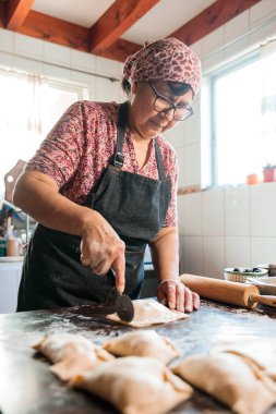 Mirasın Lezzetleri: Latin Yaşlı Kadın Şili usulü Pişirilmiş Biftek Yemeğini Ev Mutfağının Sıcaklığında Hazırlıyor. Yüksek kalite fotoğraf