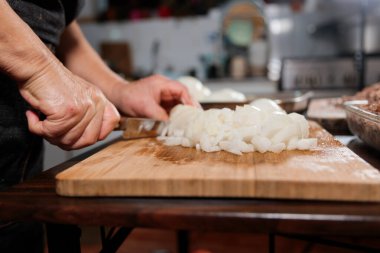 Close up of unrecognizable latin woman chopping onion and meat for making chilean baked empanadas. High quality photo