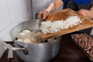 Close up of unrecognizable latin woman chopping onion and meat for making chilean baked empanadas. High quality photo