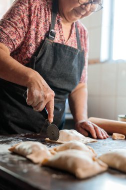 Mirasın Lezzetleri: Latin Yaşlı Kadın Şili usulü Pişirilmiş Biftek Yemeğini Ev Mutfağının Sıcaklığında Hazırlıyor. Yüksek kalite fotoğraf