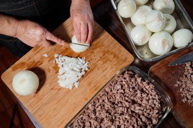 Close up of unrecognizable latin woman chopping onion and meat for making chilean baked empanadas. High quality photo