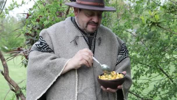 Widok Przodu Człowiek Mapuche Kraju Nosząc Wełniane Ponczo Kapelusz Jedzenie — Wideo stockowe