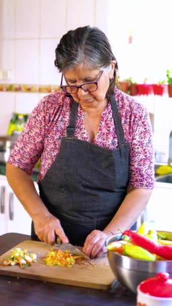 ラテンアメリカのシニアウーマン専門的に伝統的なホームキッチンのチリペッパーを切断します 高品質の4K映像 — ストック動画