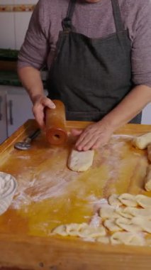 Kıdemli Latin kadın hamur yoğuruyor, ev mutfağında Şili usulü kızarmış hamur işi Calzones rotoları pişiriyor. - Evet. dikey 4k görüntü