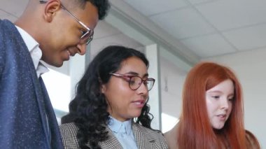 Genç Latin iş adamları bir toplantı odasında birlikte çalışıyorlar, bir proje üzerinde işbirliği çabalarına yakın çekim yapıyorlar.