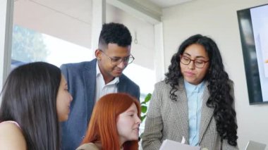 Coşkulu bir ofiste iş stratejileri geliştiren ve paylaşan çok ırklı genç profesyonellerden oluşan bir grup.