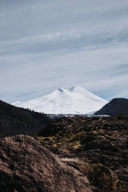 Snow-covered Llaima Volcano in Conguillio National Park, Chile, framed by a vast and untouched wilderness landscape. High quality photo clipart