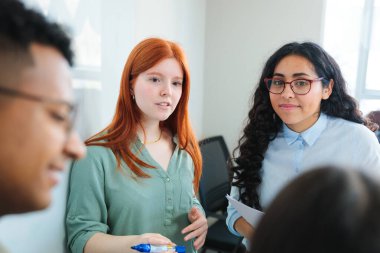 Projeler üzerinde işbirliği yapan, takım çalışması ve yüksek üretkenlik sergileyen genç profesyonel veya öğrencilerle dolu parlak ve çağdaş çalışma alanı