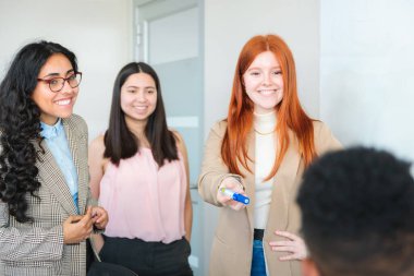 Genç Latin Yönetici Genç Profesyonellerden oluşan bir ekibi canlı ofis ortamında yönetiyor. Yüksek kalite fotoğraf