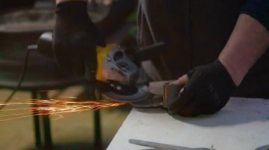 Arka Avluda İşçi Elektrikli Açı Öğütücüsünü Kullanarak Dikkatlice Polonyalı Metal Aletleri Yetenek ve Hassasiyetle Kullanıyor. Yüksek kalite 4k görüntü
