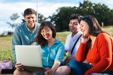 Bir grup öğrenci dizüstü bilgisayar kullanıyor, dışarıda öğrenmenin ve parkta iş birliği yapmanın tadını çıkarıyorlar. Okula geri dön.