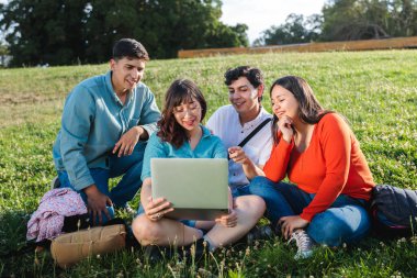 Bir grup öğrenci dizüstü bilgisayar kullanıyor, dışarıda öğrenmenin ve parkta iş birliği yapmanın tadını çıkarıyorlar. Okula geri dön.