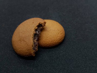 Siyah arka planda çikolata dolgulu lezzetli çikolatalı kurabiye 