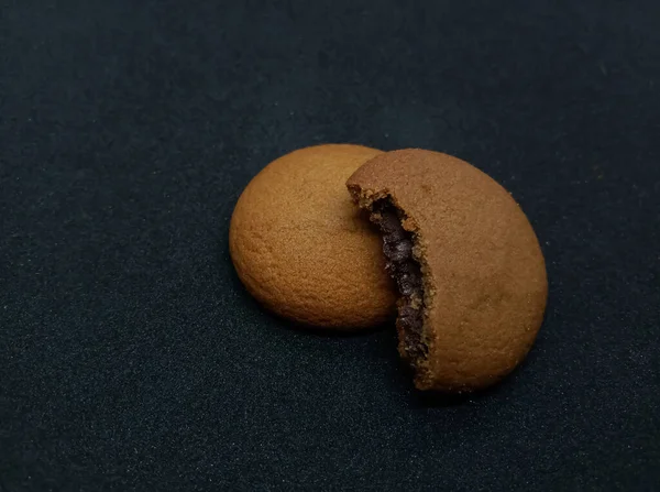 Siyah arka planda çikolata dolgulu lezzetli çikolatalı kurabiye 