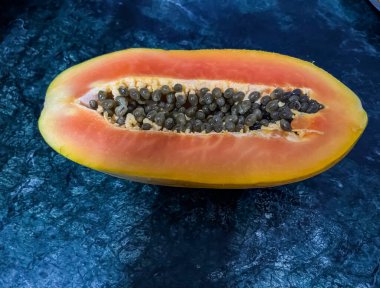 Yarı yarıya kesilmiş papaya ve siyah tohum.