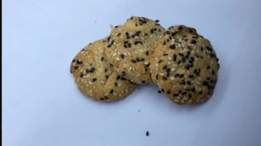 Susam tohumları serpiştirilmiş bisküviler beyaz arka planda yuvarlaktır. 