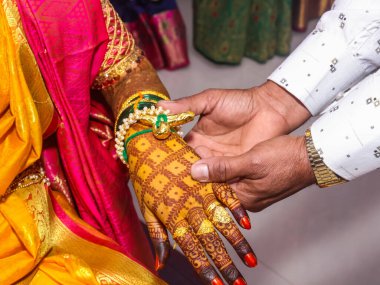 Bir Maharashtrian 'ın Hint düğün töreninde gelinin bileğine zerdeçal bağlamak.
