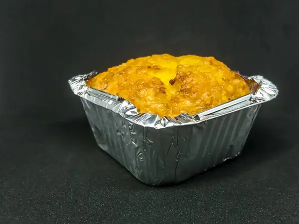 Mısır ekmekli kek ya da tatlı mısır keki, alüminyum folyo tepside tereyağlı kek. konu üzerinde siyah arkaplan seçici odak.
