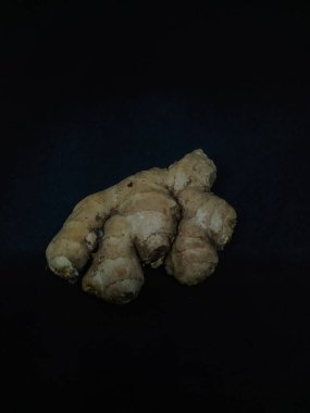 ginger root (Zingiber officinale) or ginger, is widely used as a spice and a folk medicine, on black background  clipart