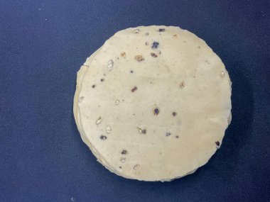 Çiğ, ince, mercimek unundan yapılmış ve karabiberle tatlandırılmış papad. Hint atıştırmalıkları siyah arkaplan 