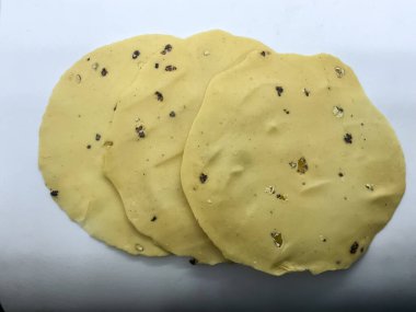 Çiğ, ince, mercimek unundan yapılmış ve karabiberle tatlandırılmış papad. Hint atıştırmalıkları beyaz arka plan 