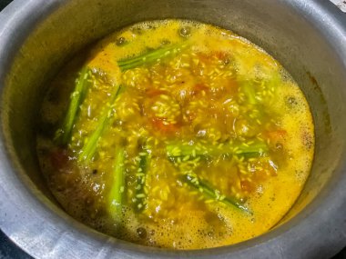 Khichdi ev mutfağında bir tencerede pişiriliyor. Tavuk budu sebze, domates, pirinç ve baharat.