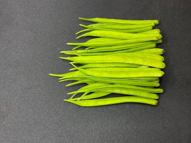 Bir bakla yığını, fasulye kümesi ayrıca guar fasulyesi ya da koyu gri arka planda guar kapsülü olarak da bilinir. 