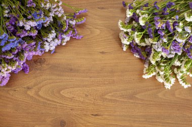 Kahverengi ahşap arkaplanda fotokopi alanı olan Statice çiçekleri