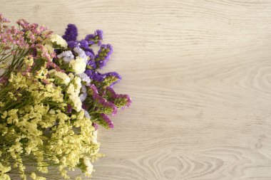 Renkli istatik çiçekleri ve açık ahşap arka planla yapılan davetler için arkaplan