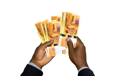 Siyah elli takım elbiseli, elinde 3D Comorian frangı var.