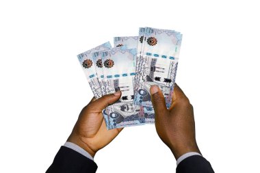 Suudi Riyal notları içeren takım elbiseli siyah eller.