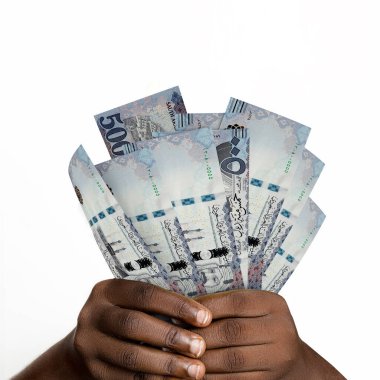 Suudi riyal notalarını tutan siyah eller. Suudi Arabistan para birimi notlarını tutan Eller 'e yakın çekim