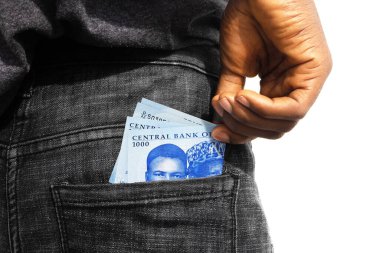Black lady putting few Nigerian naira notes into her back pocket. Removing money from pocket, hold money