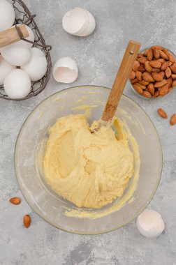 Adım adım tarif et. İtalyan cantucini kurabiyeleri yapma süreci. Gri beton arka planda bir kasedeki hamuru bitirdim. Üst görünüm