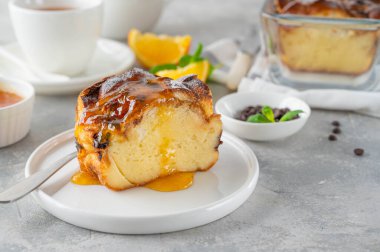 Homemade bread pudding with chocolate chips on a gray concrete background. Selective focus, copy space