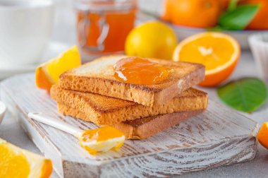 Turuncu marmelatlı tost mu yoksa gri arka planda bir fincan çay ile portakal reçeli mi? Nefis bir kahvaltı. Boşluğu kopyala