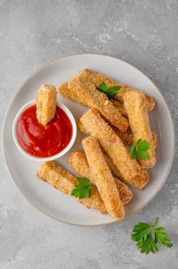 Gri bir arka planda domates sosuyla servis edilen haşlanmış sarımsaklı parmesan kabağı çubukları. Vejetaryen sağlıklı yemek. Seçici odak