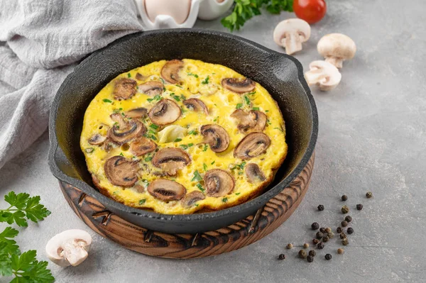 Beyaz ahşap arka planda mantarlı omlet ve tavada otlar. Sağlıklı kahvaltı. Üst Manzara. Boşluğu kopyala
