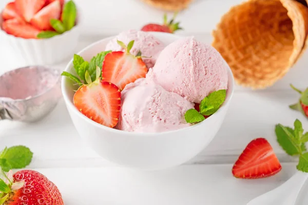 stock image Strawberry ice cream with fresh berries in a bowl on a white wooden background. Selective focus.