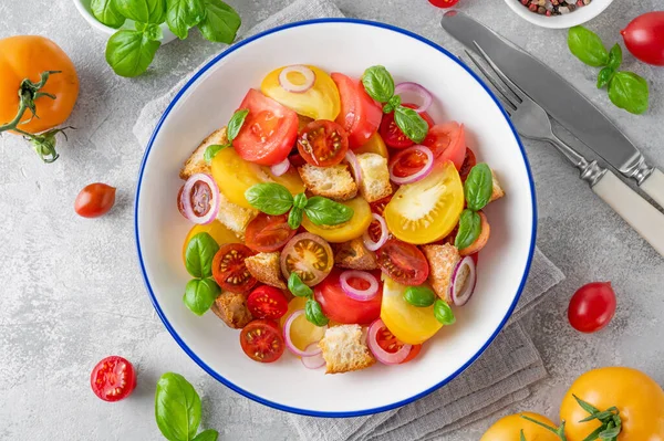 Stock image Traditional Italian Panzanella salad with tomatoes, onion, fresh basil and bread. Vegetarian dish. top view.