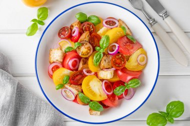 Geleneksel İtalyan Panzanella salatası, domates, soğan, taze fesleğen ve ekmek. Vejetaryen yemeği. en üstteki görünüm.